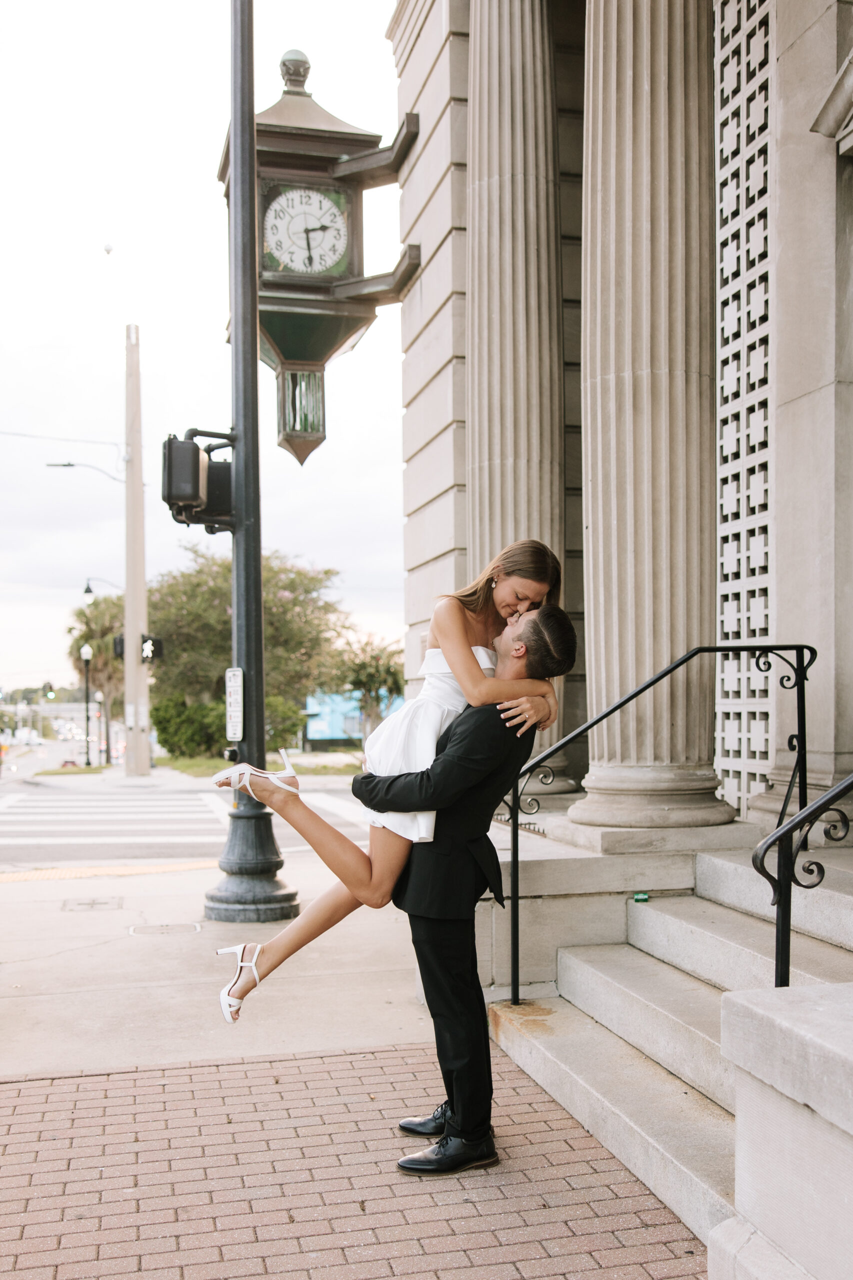 Man picking up his fiancé and kissing her in the streets of downtown ocala